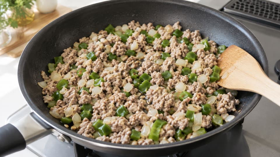 豚ひき肉と玉ねぎ、角切りのピーマンに火を通す