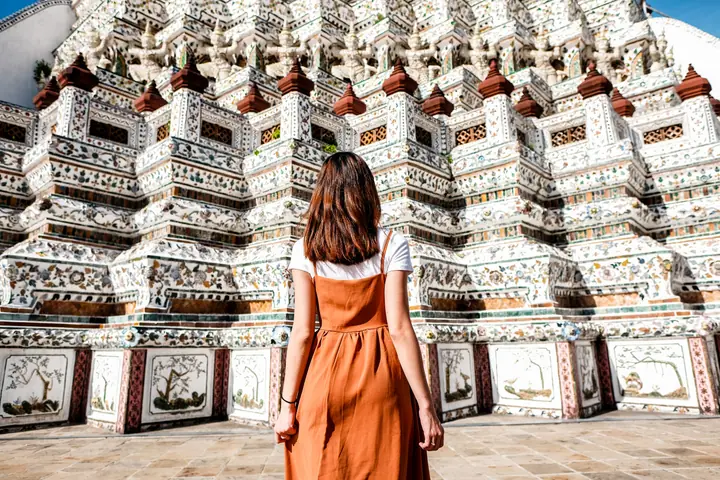 半袖Tシャツを重ねたワンピースでワットアルンの大仏塔を眺める旅行者
